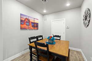 Dining room with wood finished floors and recessed lighting