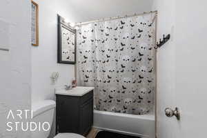 Bathroom featuring shower / bath combination with curtain and vanity