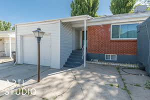 Doorway to property with brick siding and an attached garage