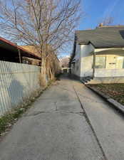 View of side of home featuring roof with shingles and concrete driveway