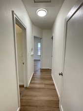 Hall with light wood-style flooring and baseboards