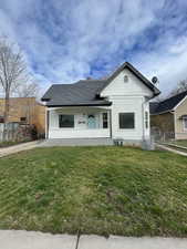 View of front of property with covered porch, roof with shingles, and a chimney