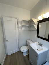Half bath featuring vanity and dark wood-style flooring