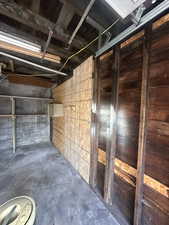 Interior space featuring concrete block wall and unfinished concrete floors