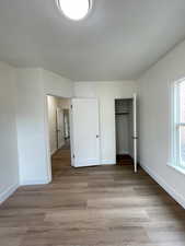 Unfurnished bedroom featuring light wood-style floors and a closet