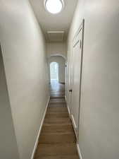 Corridor with arched walkways and dark wood finished floors