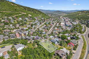 Aerial view of property and surrounding area with property boundaries highlighted and a mountain backdrop