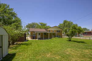 Back of house with brick siding, a patio, a fenced backyard, and a playground