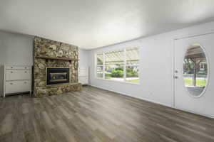 Unfurnished living room with wood finished floors and a fireplace