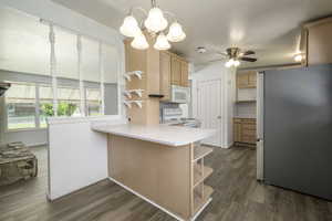 Kitchen with white appliances, open shelves, a peninsula, light countertops, and a ceiling fan