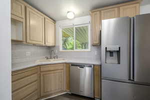 Kitchen featuring stainless steel appliances, light brown cabinets, and light countertops