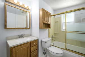 Full bath featuring vanity and bath / shower combo with glass door