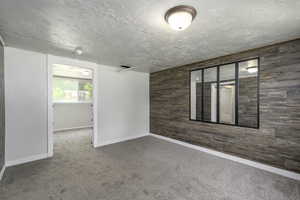 Spare room featuring wooden walls and carpet