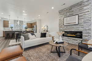 Living room with light wood-type flooring, recessed lighting, and a fireplace