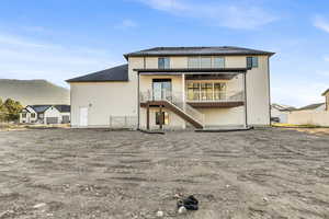 Rear view of house featuring a patio, stairs, stucco siding, a mountain view, and roof with shingles