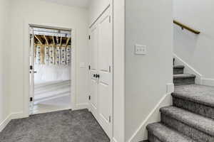 Hall with dark carpet and stairway
