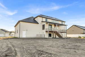 Back of house featuring stairs, stucco siding, a deck, a patio, and a shingled roof