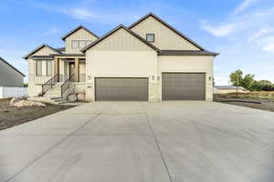 Modern inspired farmhouse featuring board and batten siding, concrete driveway, and a garage
