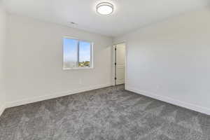 Carpeted empty room with baseboards