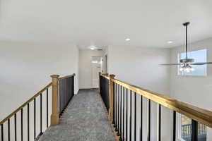 Hall featuring carpet, recessed lighting, and an upstairs landing