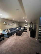 Living room featuring carpet, recessed lighting, and stairway