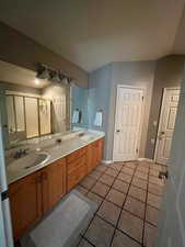 Full bath with tile patterned flooring, double vanity, and a shower stall