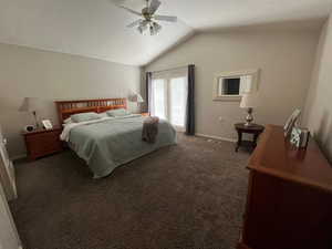 Carpeted bedroom featuring lofted ceiling and ceiling fan