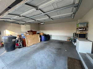 Garage featuring refrigerator and a garage door opener