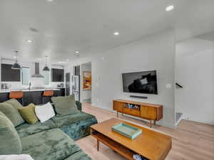 Living area with recessed lighting, light wood-style flooring.