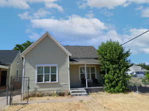 View of front of property with a porch, a gate, and a shingled roof