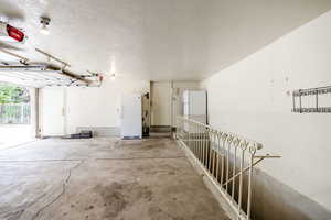 3 car Garage featuring freestanding refrigerator and a garage door opener