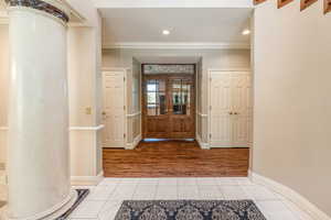 Tiled entrance foyer featuring crown molding and recessed lighting