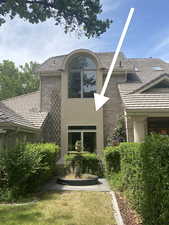 Rear view of house featuring brick siding and stucco siding