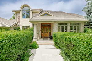 View of exterior entry with a tile roof and brick siding