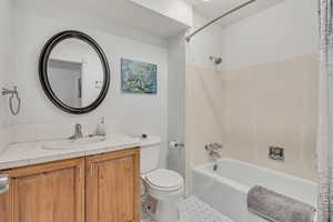 Full bathroom with shower / bathtub combination with curtain and vanity. On main floor.