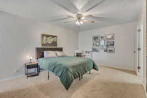 Primary Bedroom. Carpeted bedroom with a textured ceiling and a ceiling fan