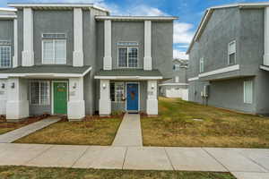 View of front facade with stucco siding and a front lawn