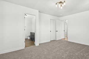 Unfurnished bedroom featuring carpet floors and ensuite bathroom