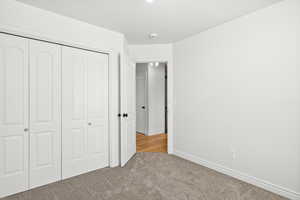 Unfurnished bedroom featuring a closet and carpet