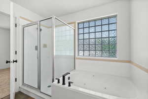 Bathroom featuring a shower stall and a whirlpool tub