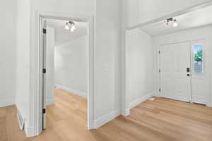 Foyer entrance with light wood-type flooring and baseboards