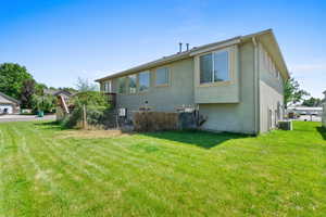 Back of house featuring stucco siding and a yard