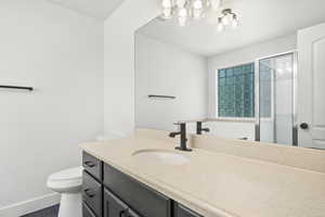 Bathroom with vanity, a shower stall, and a chandelier