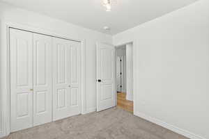 Unfurnished bedroom with carpet flooring and a closet