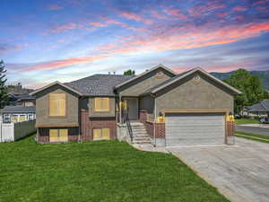 View of front of property with driveway, stucco siding, an attached garage, and roof with shingles