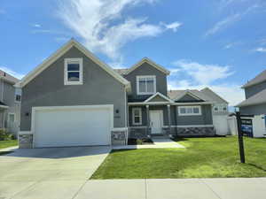 Craftsman house featuring stone siding, concrete driveway, and stucco siding