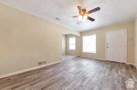 Empty room featuring wood finished floors, a ceiling fan, and a textured ceiling