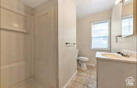 Full bathroom featuring vanity, a stall shower, and light tile patterned floors