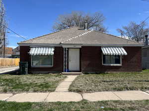 View of front facade with a tiled roof and brick siding