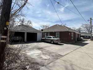 View of side of property featuring brick siding and a detached garage